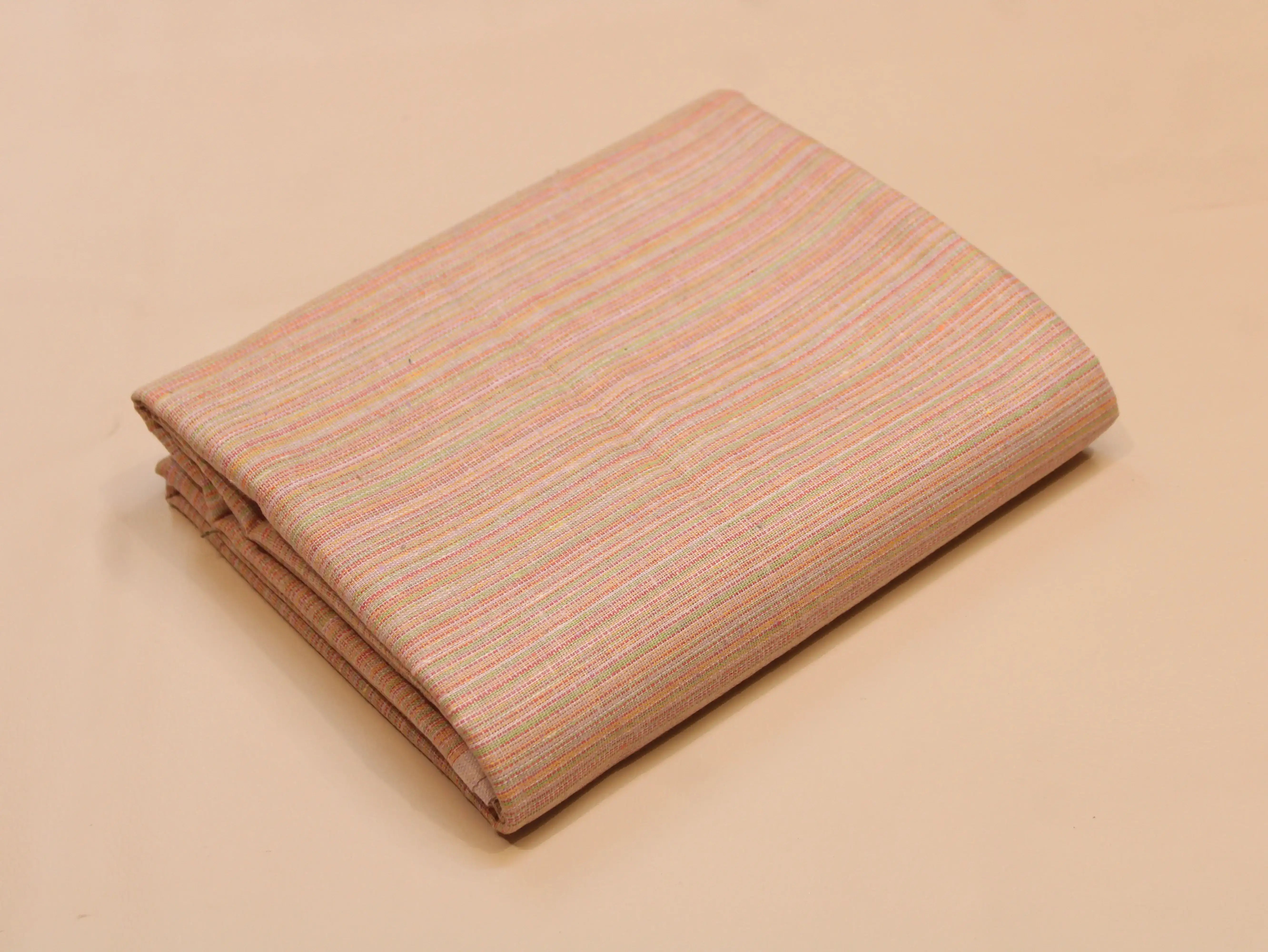 Folded pastel striped ethnic cotton fabric on neutral background