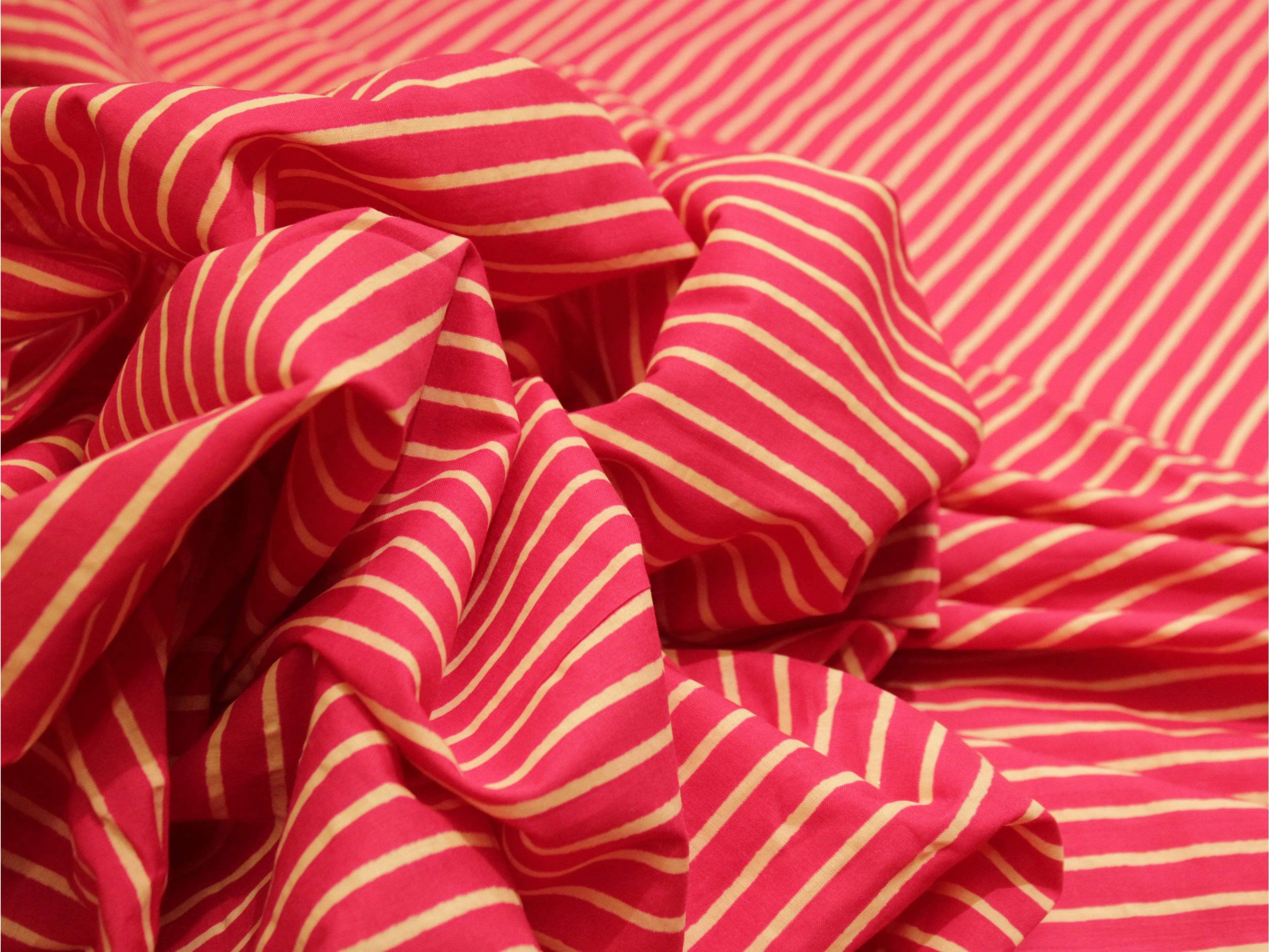 Pink and cream striped cotton fabric with soft texture and draped folds