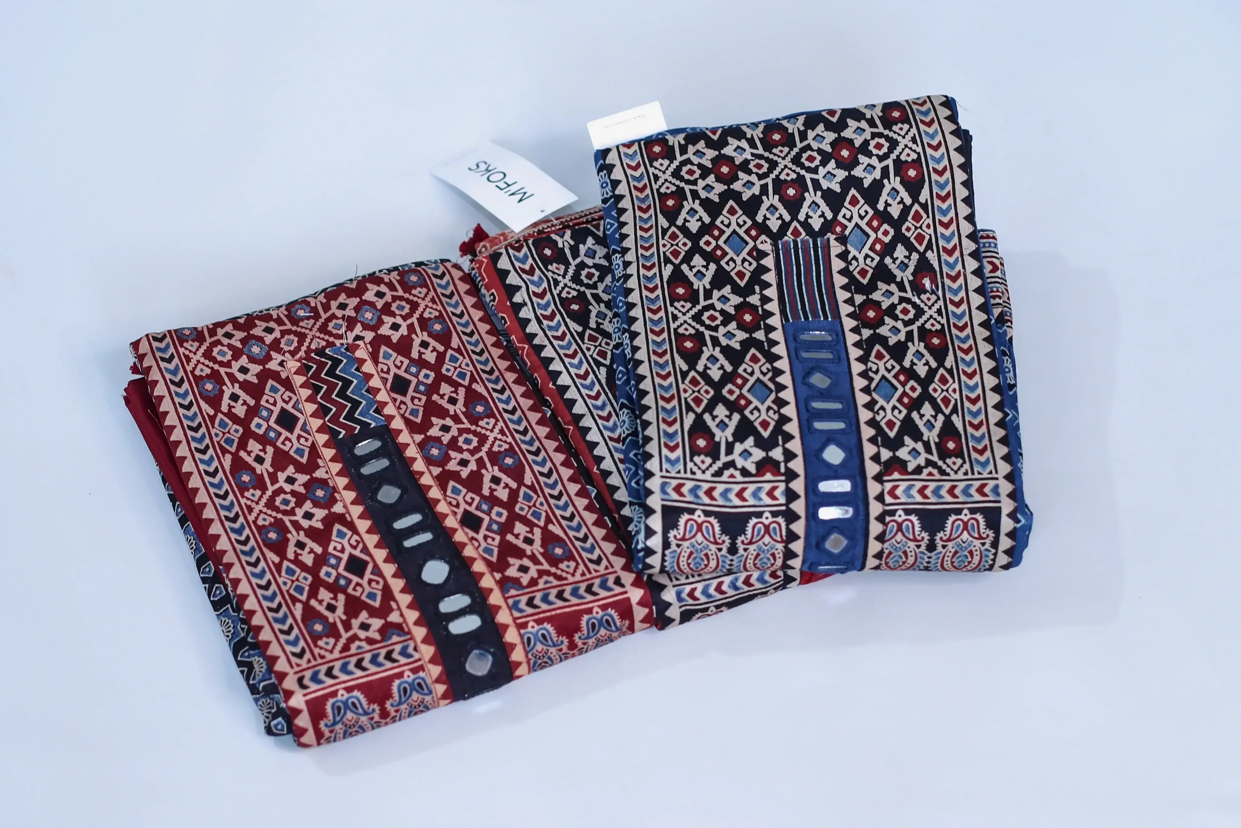 Folded unstitched cotton fabric with traditional geometric block print patterns in red and blue