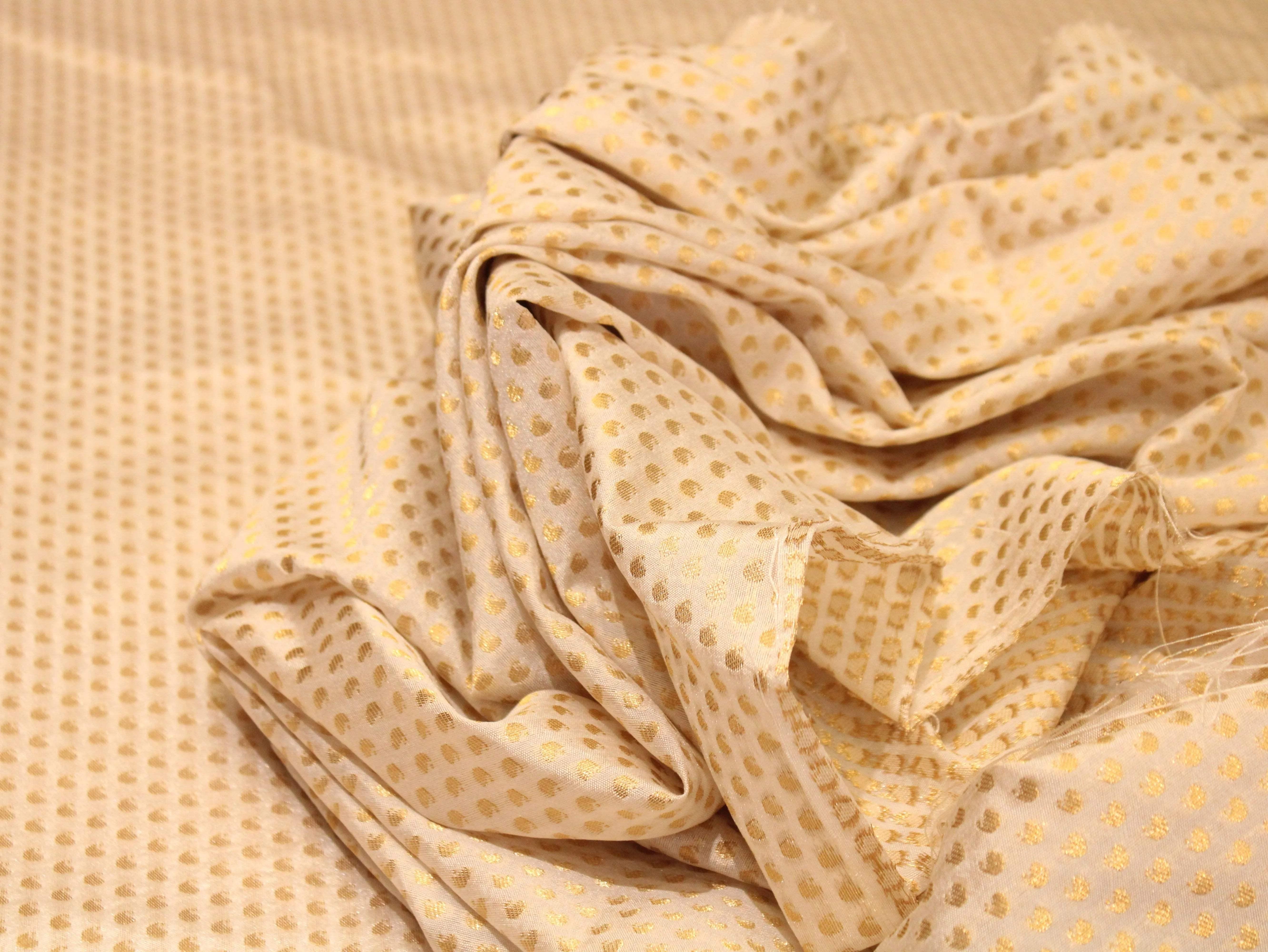 Off-white Banarasi brocade fabric with gold polka dot pattern, dyeable textile material