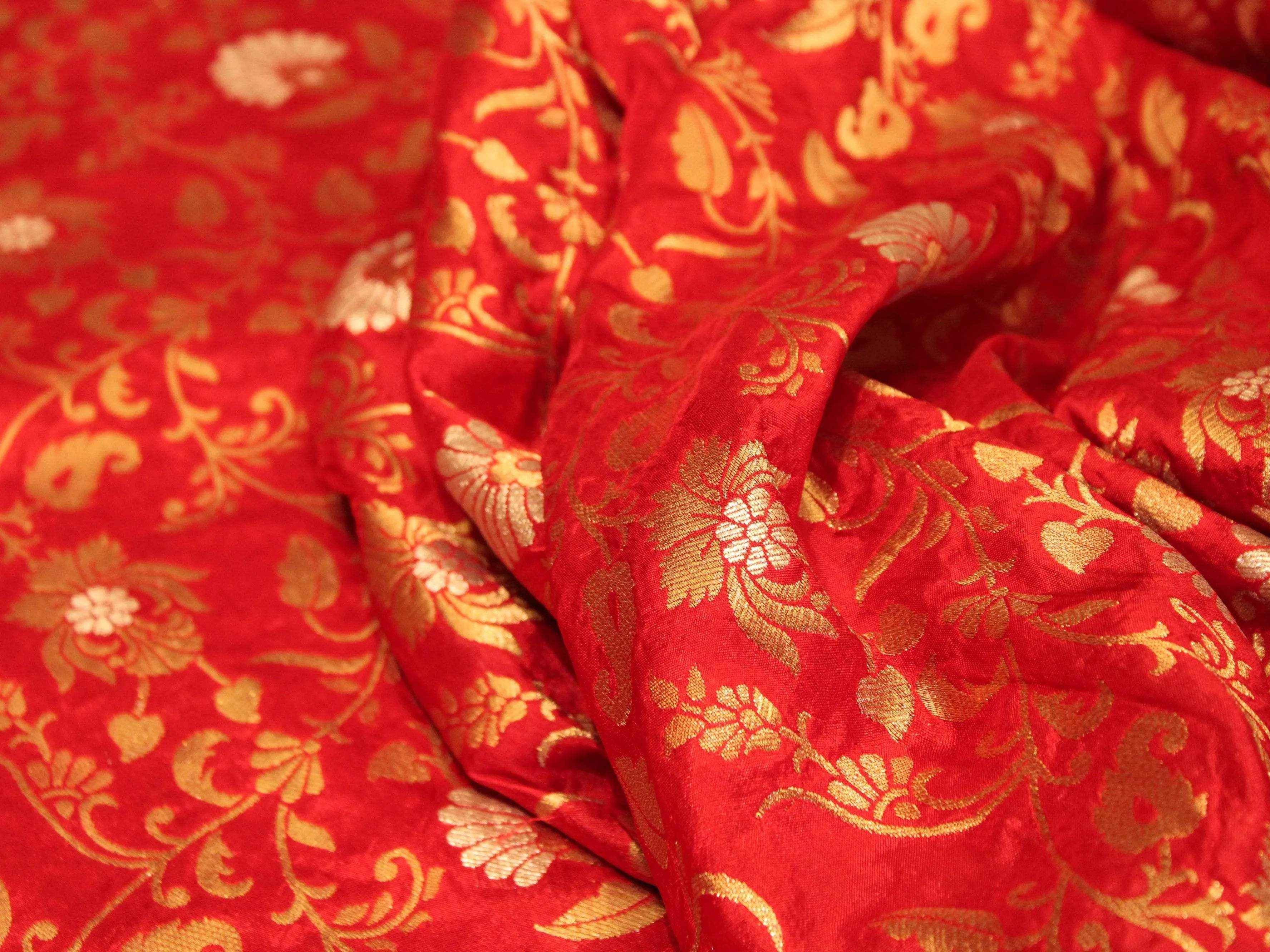 Red Banarasi floral brocade fabric with gold zari weaving and intricate floral motifs