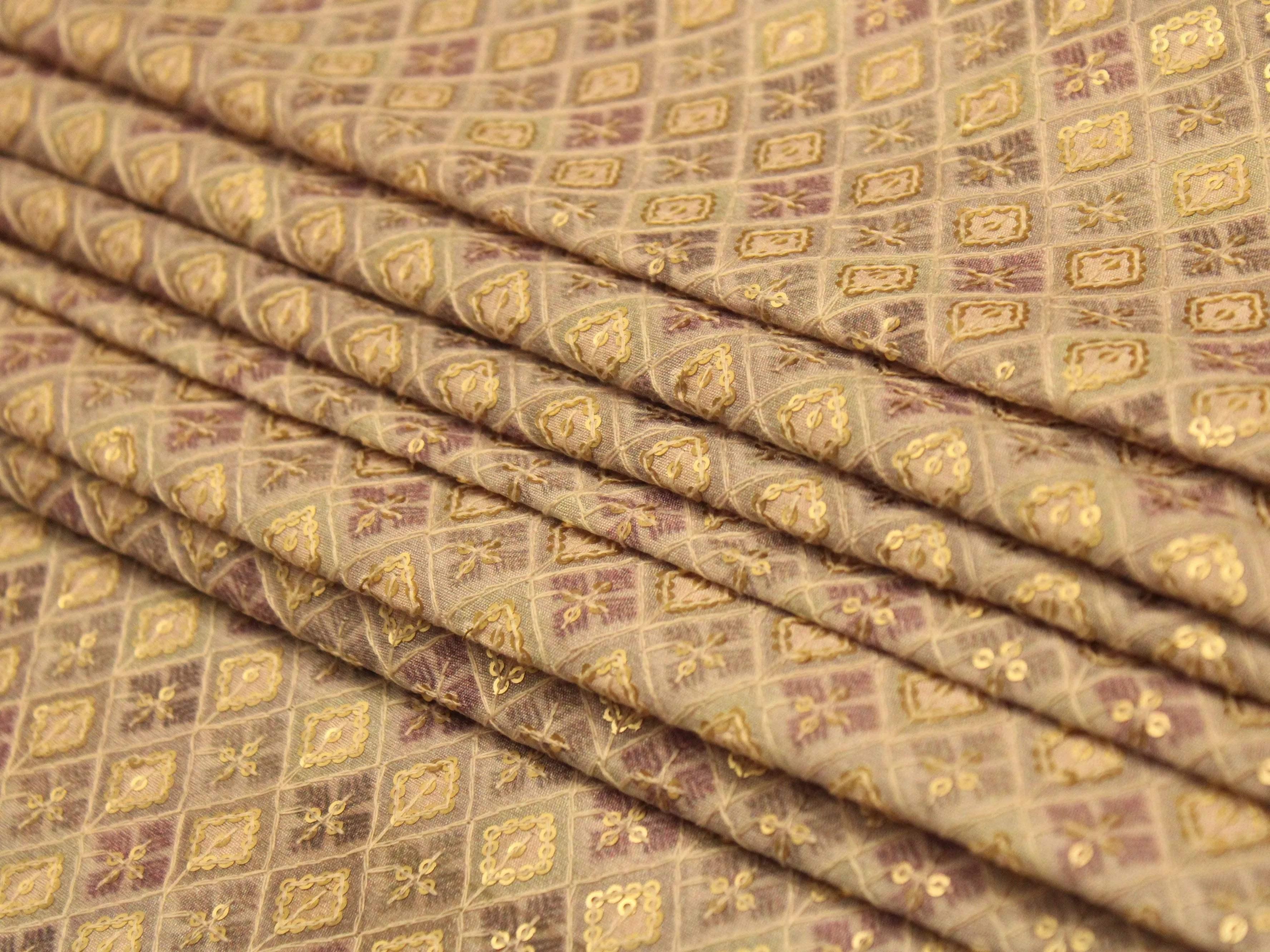 Grey silk digital print fabric with gold geometric motifs and fine texture, folded neatly