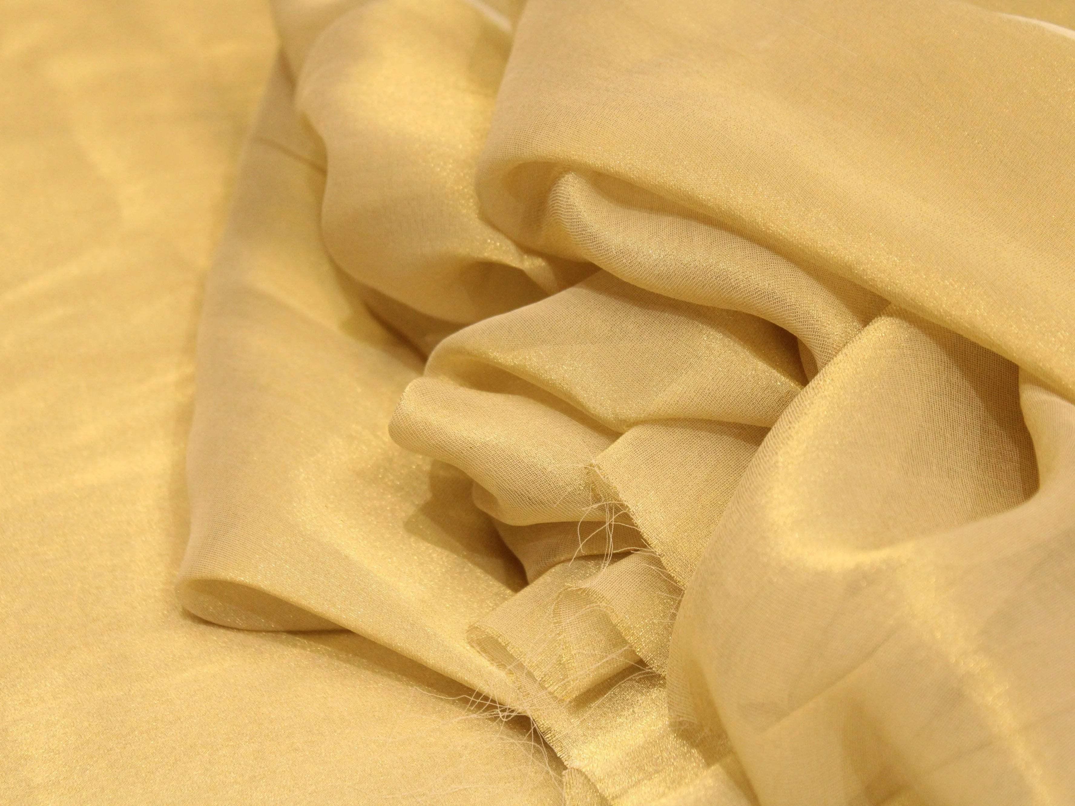 Golden dyeable chinon tissue silk fabric with a soft, sheer, and shimmery texture
