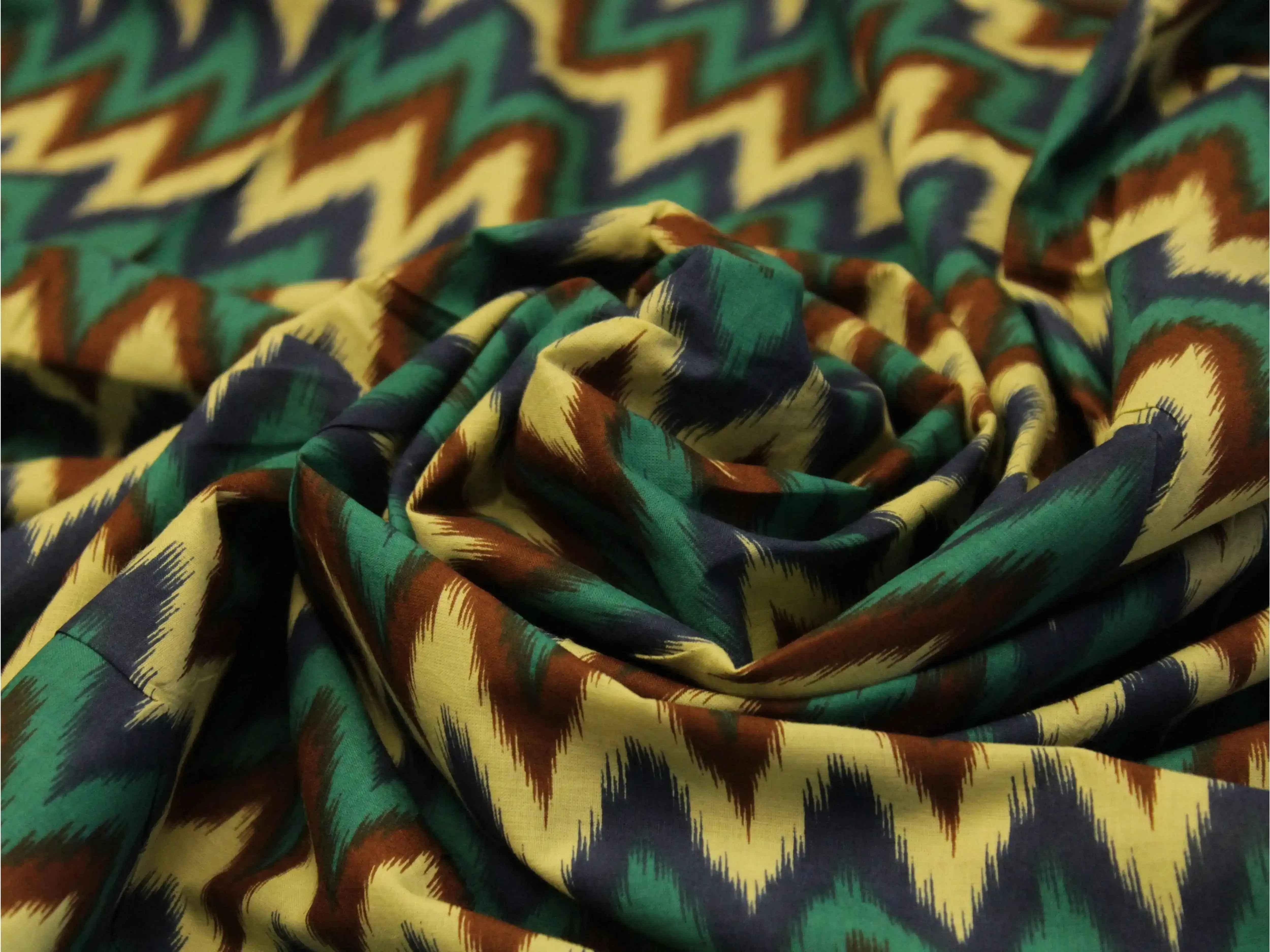 Euphoric cotton fabric with bold zigzag ikat print in green, navy, brown, and beige tones