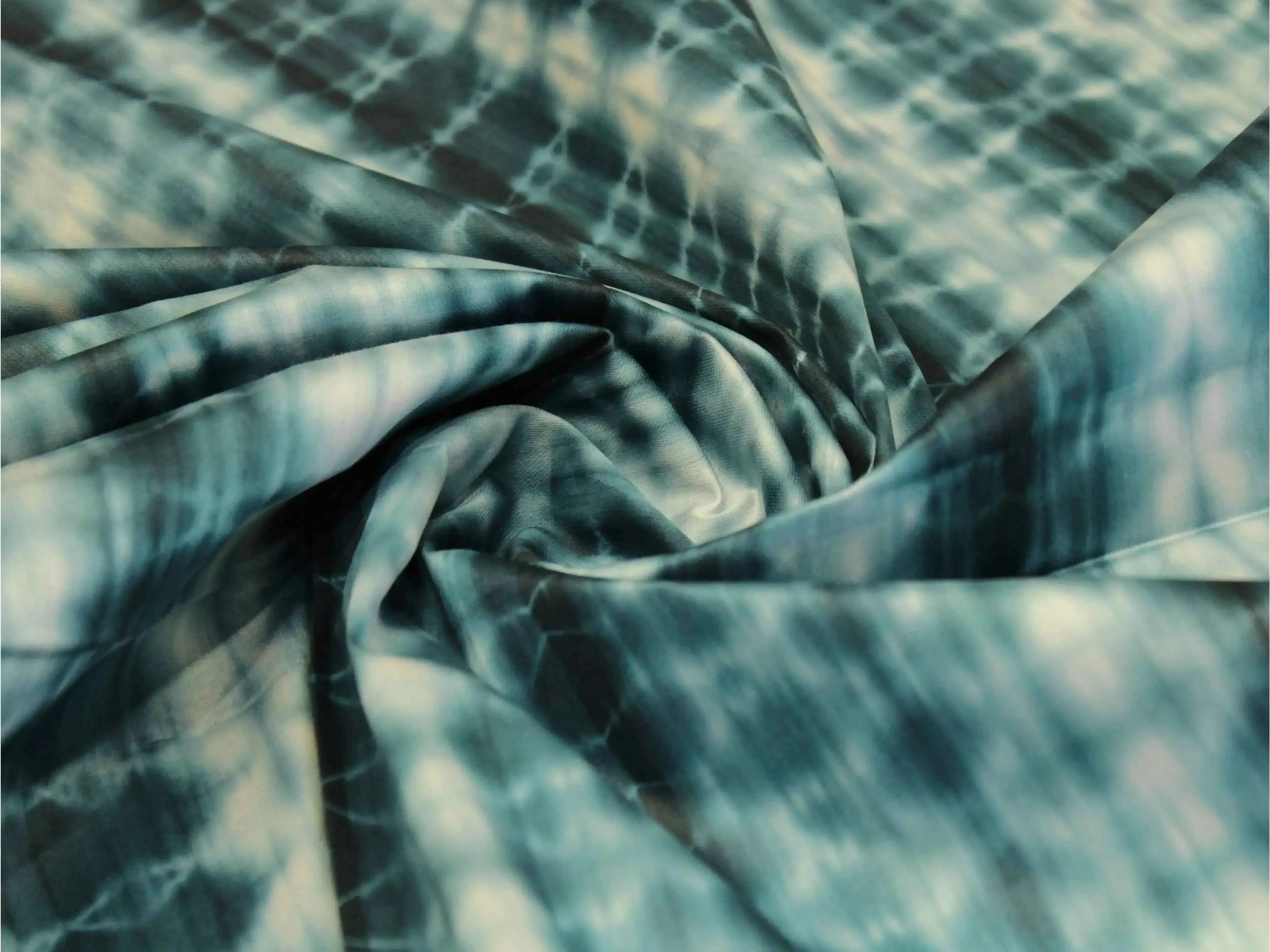 Peacock blue cotton satin fabric with abstract shibori print, soft and folded
