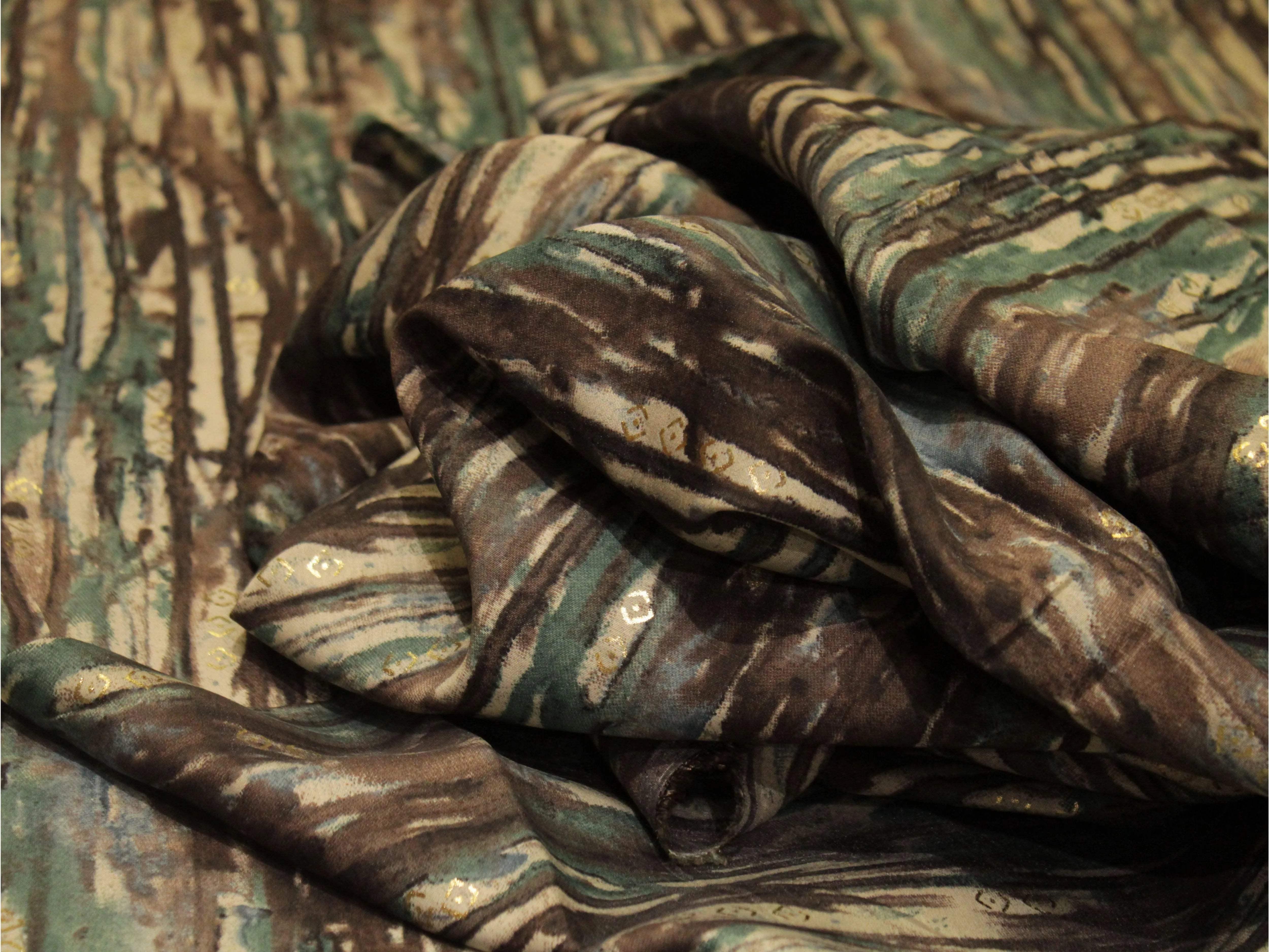 Brown and green digital print muslin silk fabric with abstract patterns and subtle shimmer