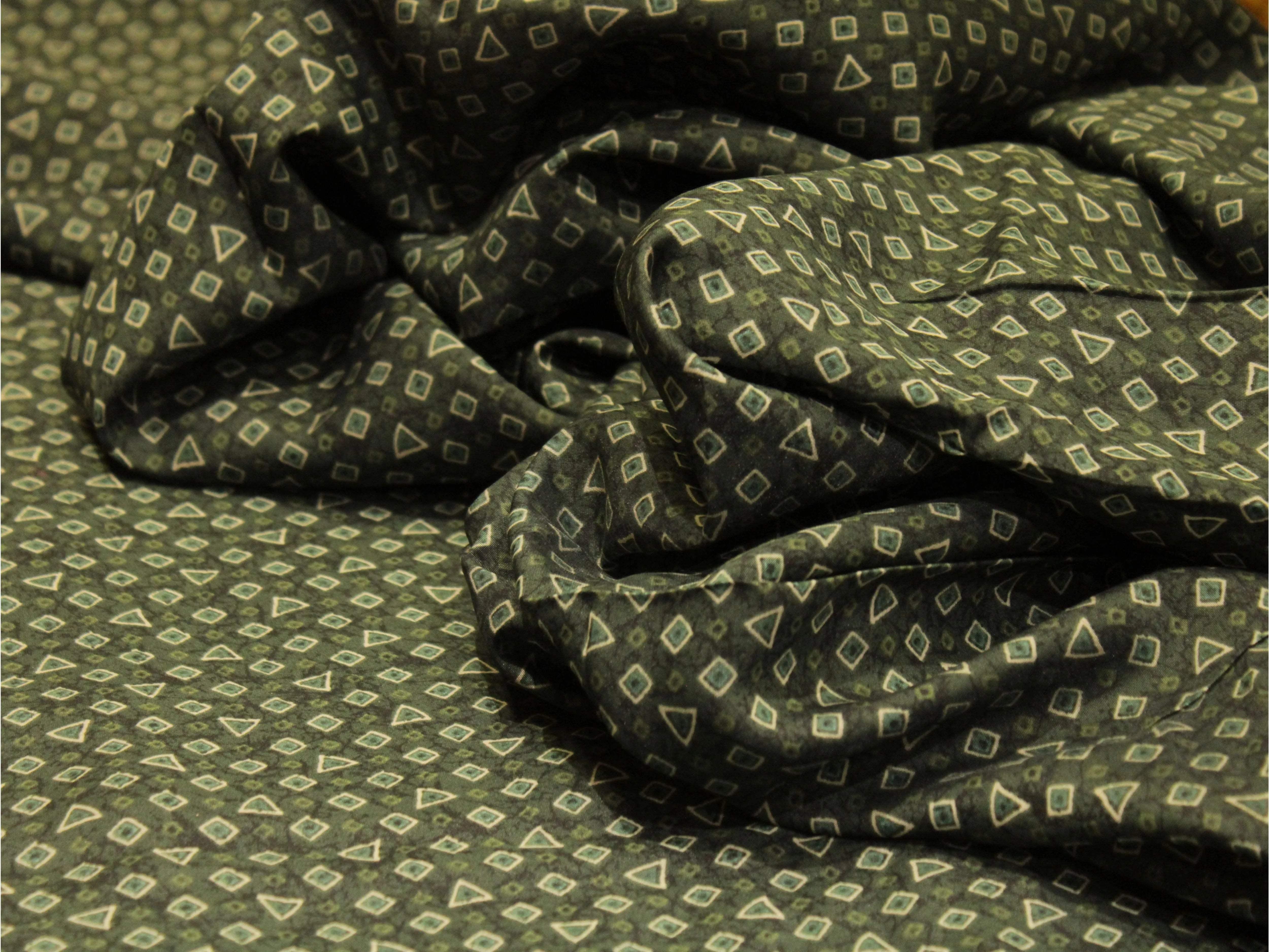 Green muslin silk fabric with geometric digital print, soft texture, ideal for ethnic wear
