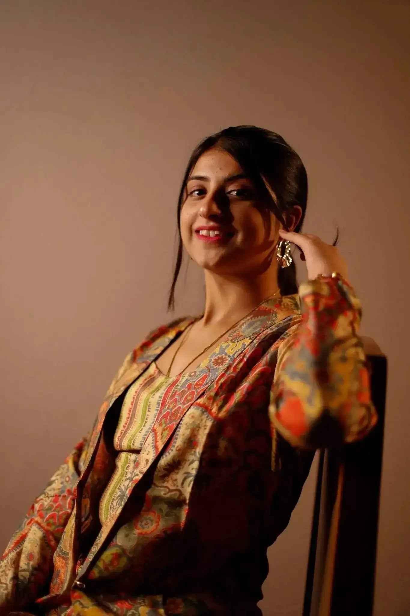 Woman wearing a colorful printed blazer with matching co-ord set, posing indoors