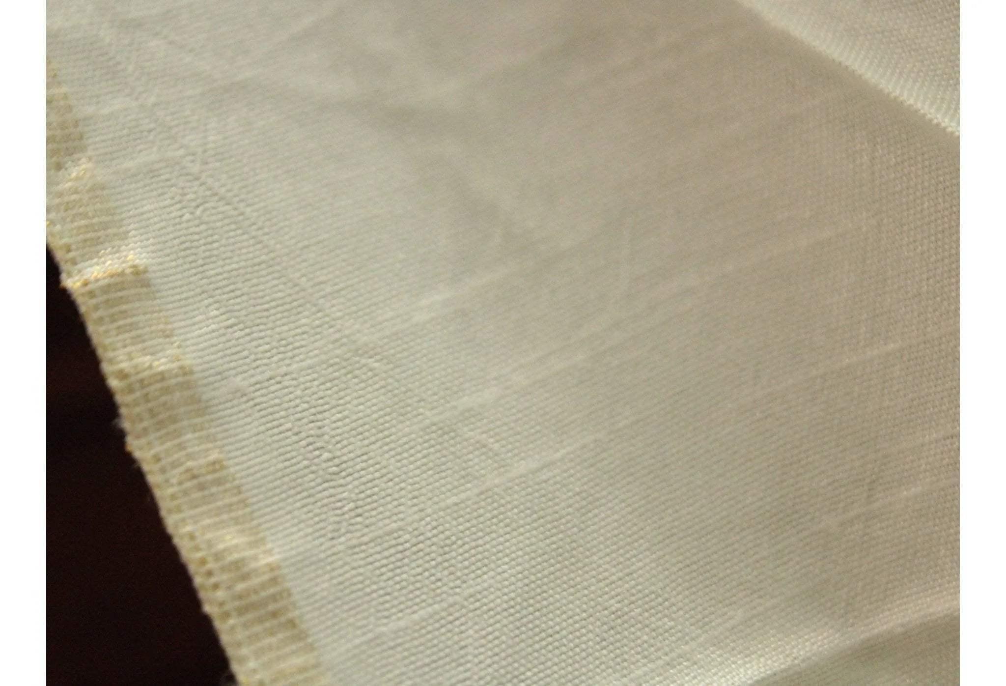 Close-up of plain cream dyeable Dola silk fabric with visible texture and raw edge