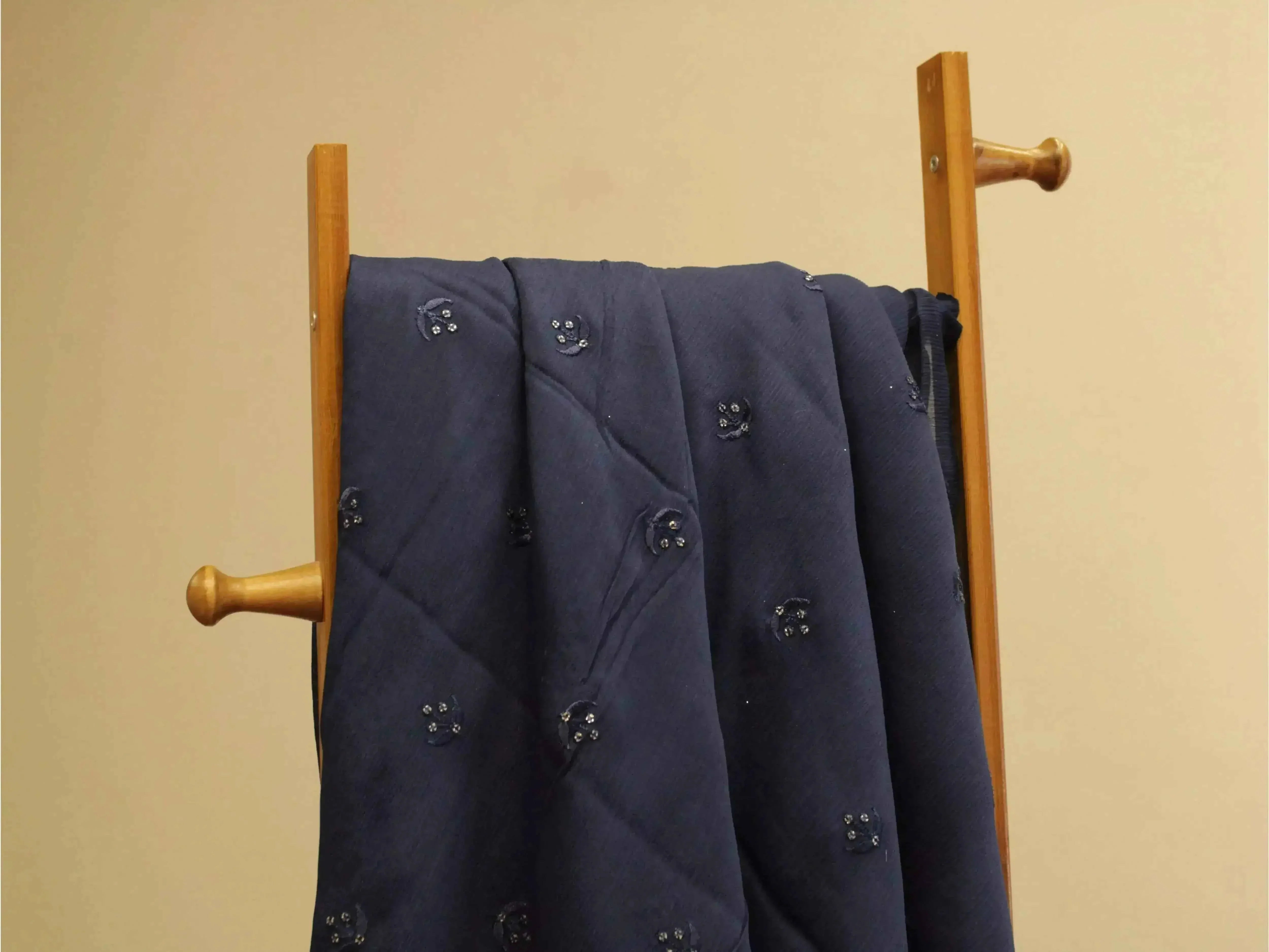 Blue pure chinon fabric with minimal buti work draped on a wooden stand