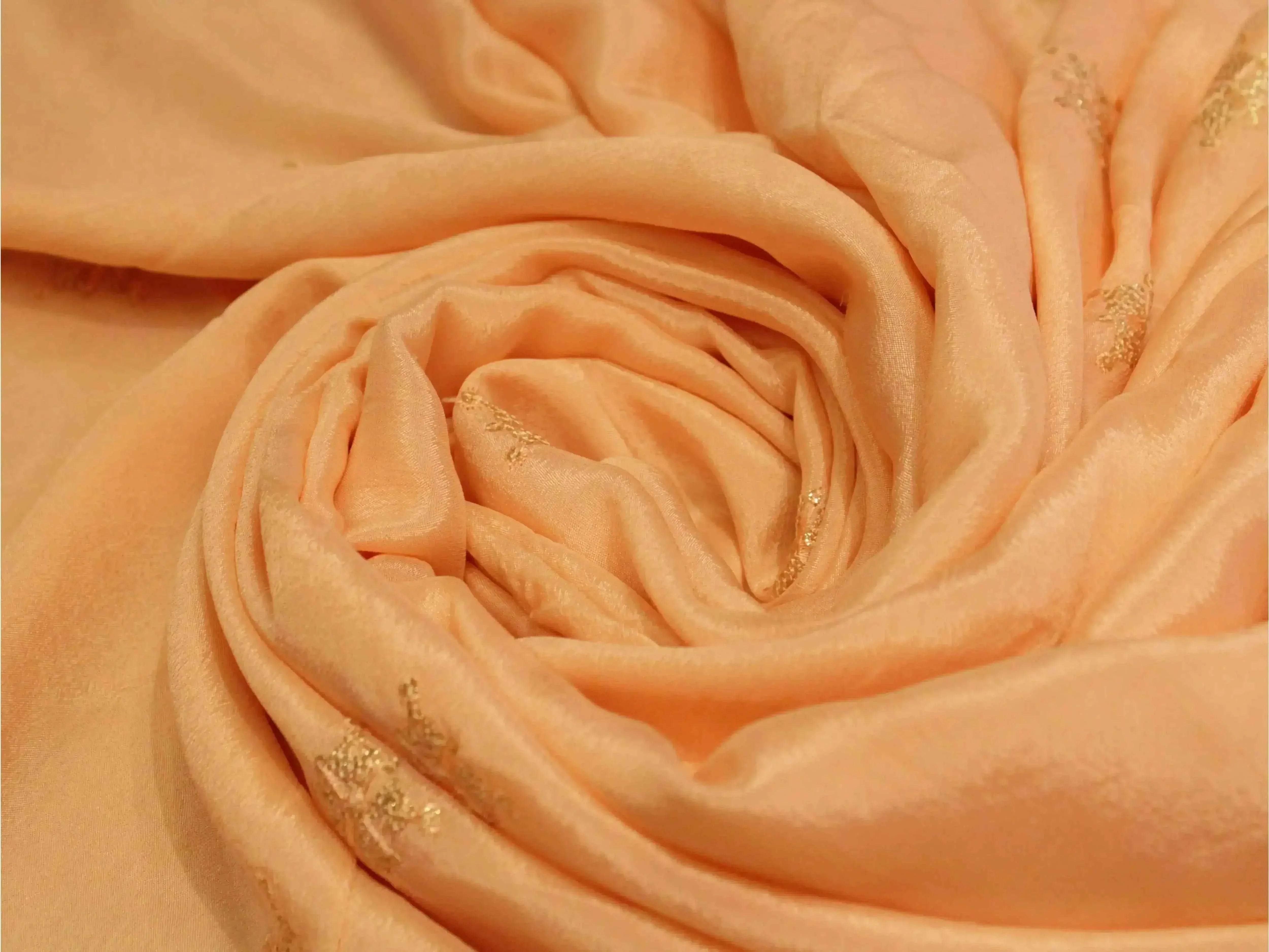 Water peach Chinon fabric with minimal buti work and soft, shimmery texture