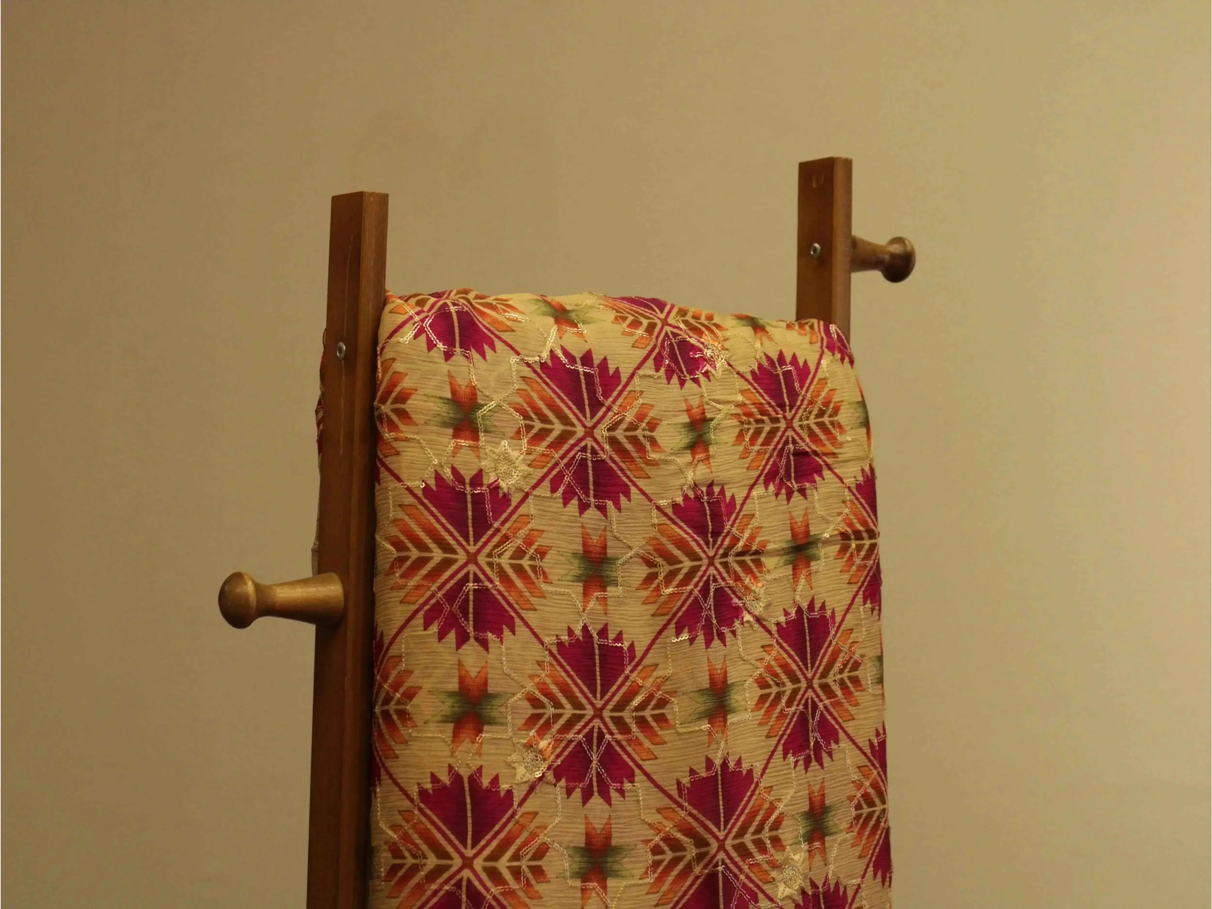 Colorful digital Chinon silk fabric with geometric floral pattern draped on wooden stand