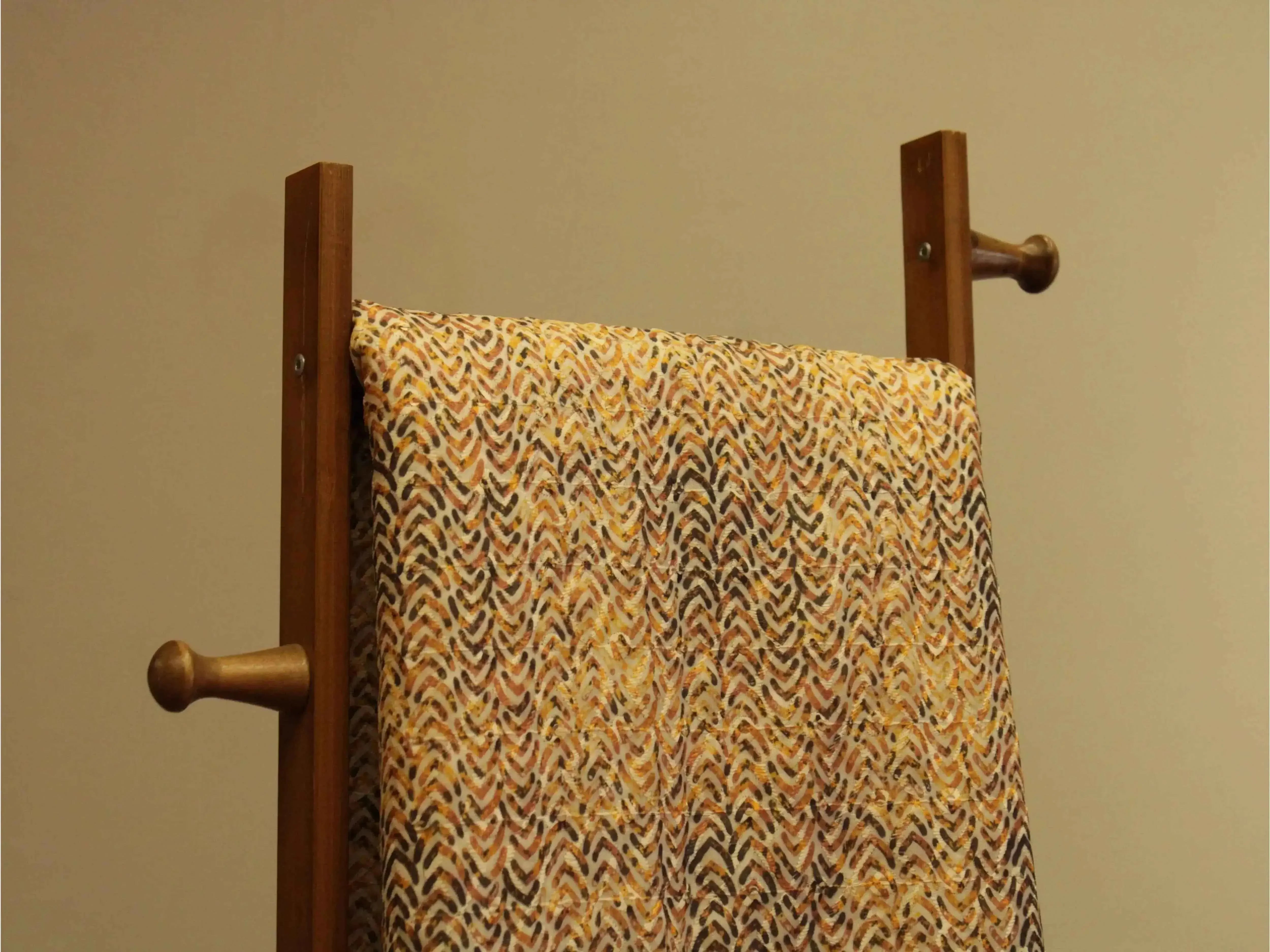Multicolor digital silk fabric with abstract chevron pattern draped on wooden stand