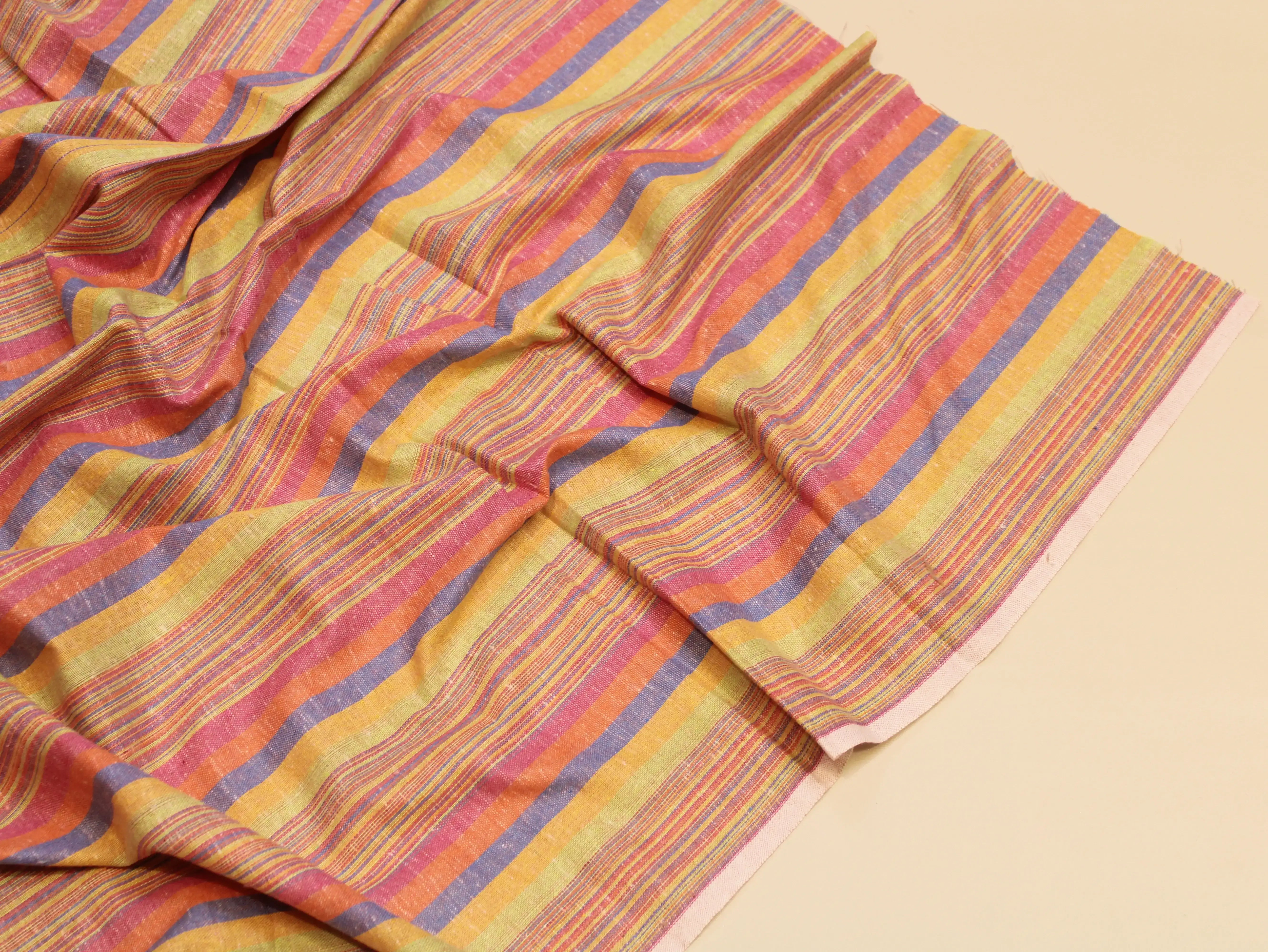 Colorful striped Indian fabric with yellow, orange, pink, and purple woven patterns