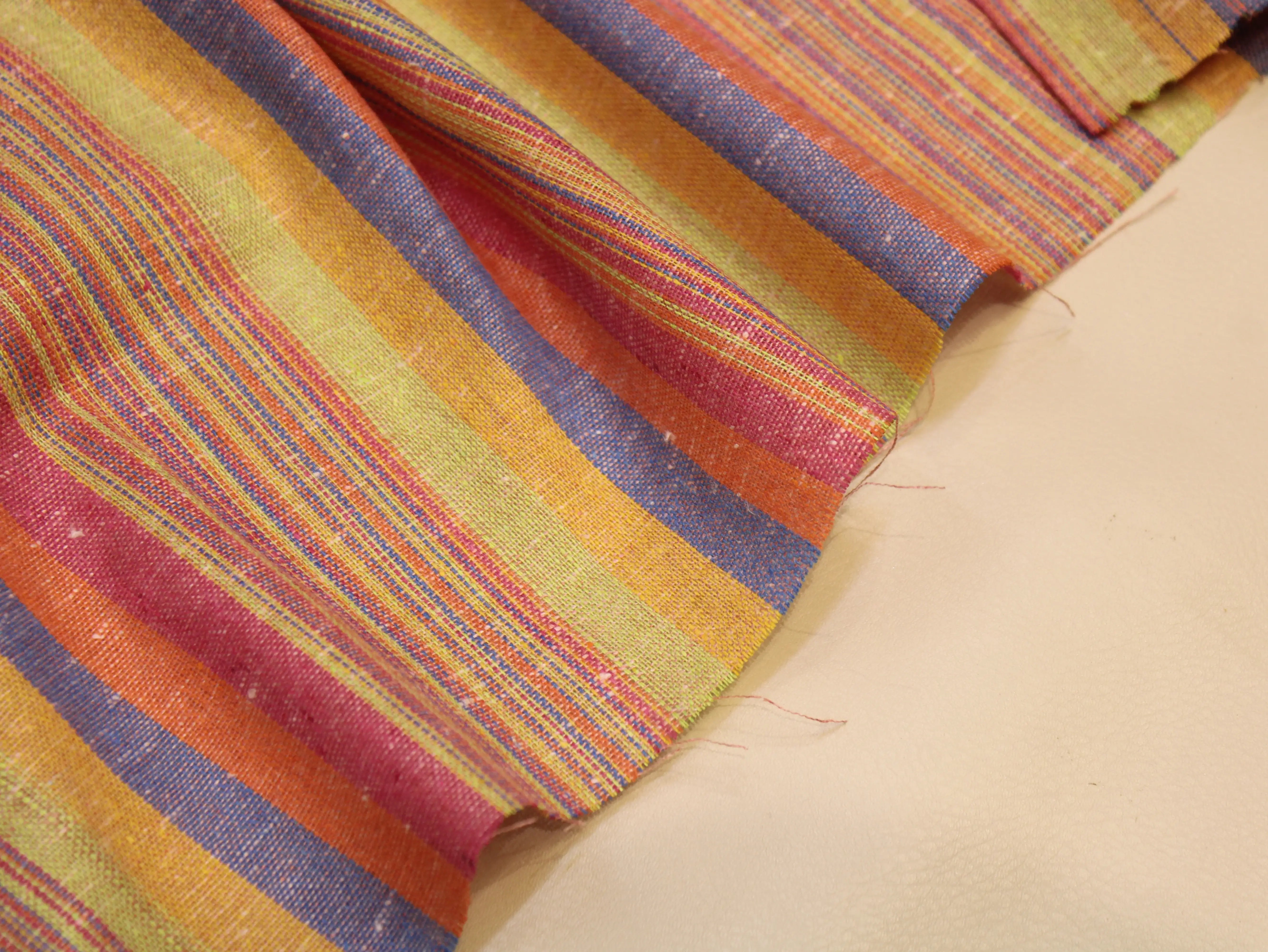 Colorful handwoven Indian fabric with vibrant stripes in pink, orange, yellow, and blue