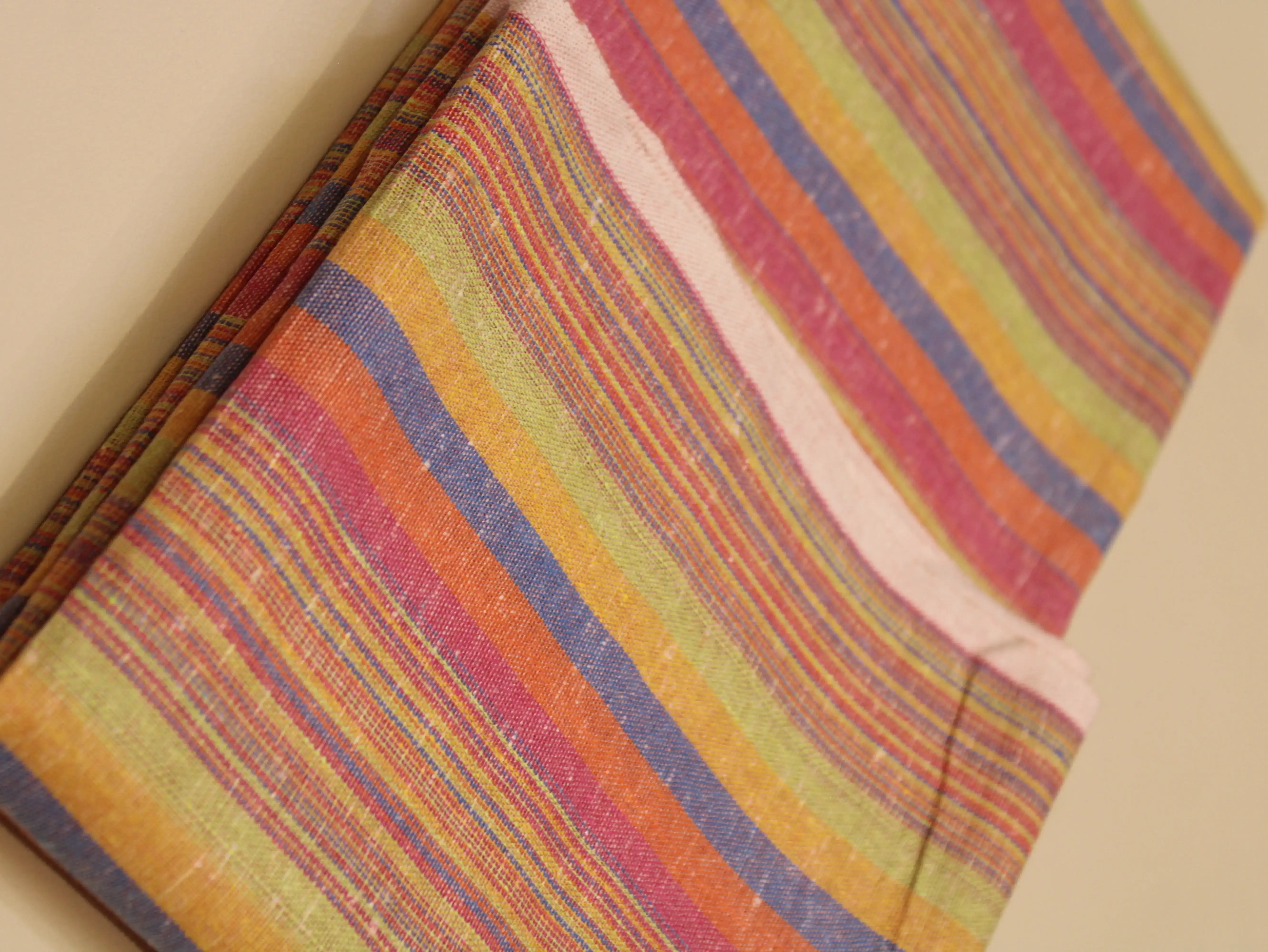 Multicolor handloom cotton fabric with vibrant stripes in orange, pink, yellow, and blue