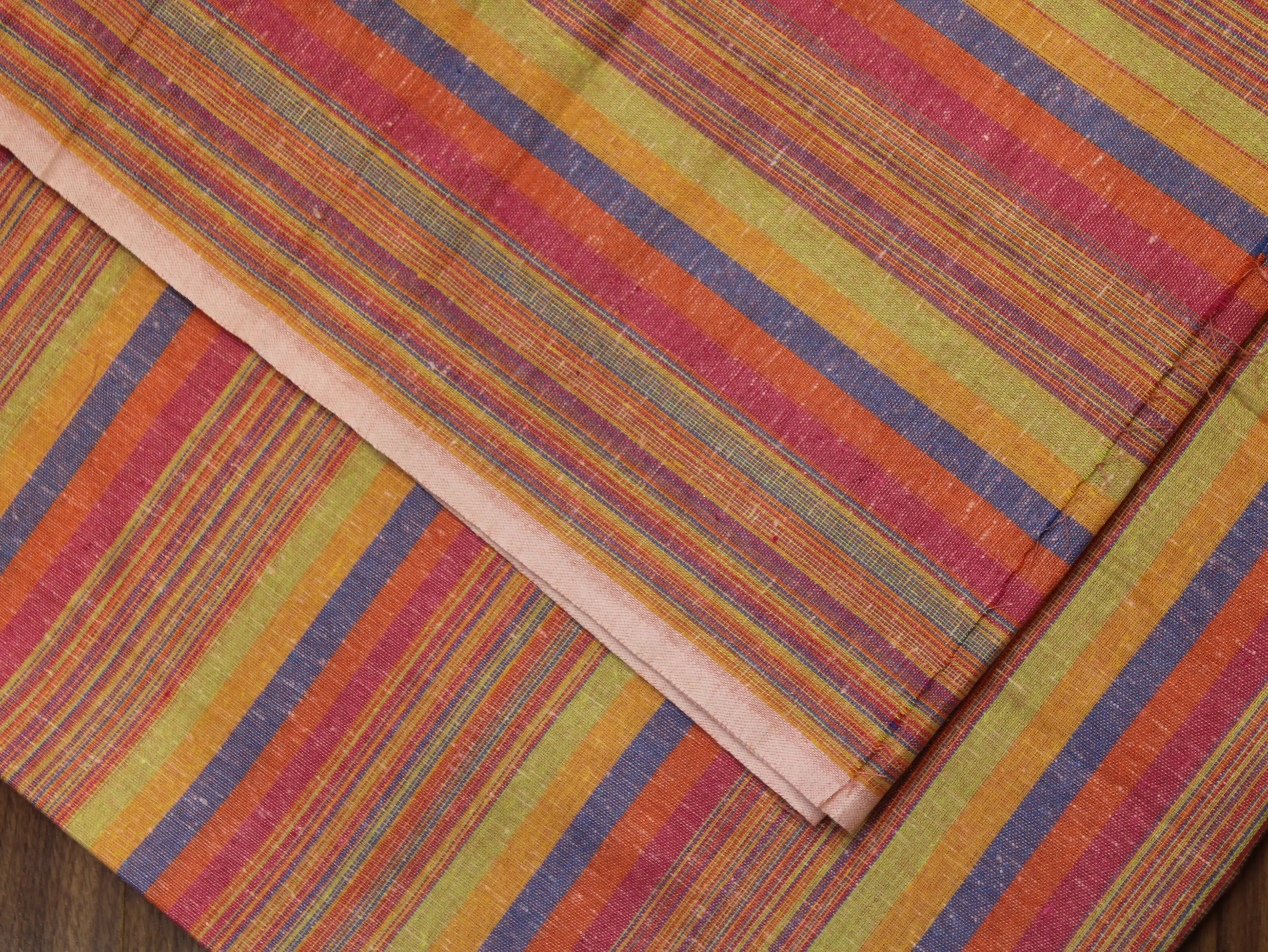 Multicolored striped Indian fabric with orange, green, and purple lines on a flat surface